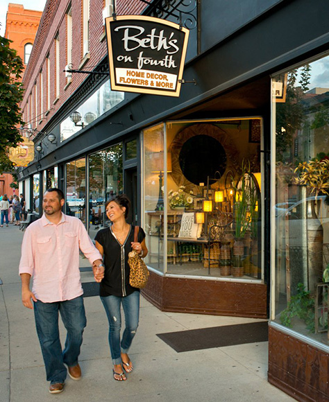 A couple stroll down a street shopping