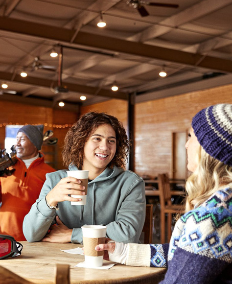 People sitting in a ski lodge talking to one another