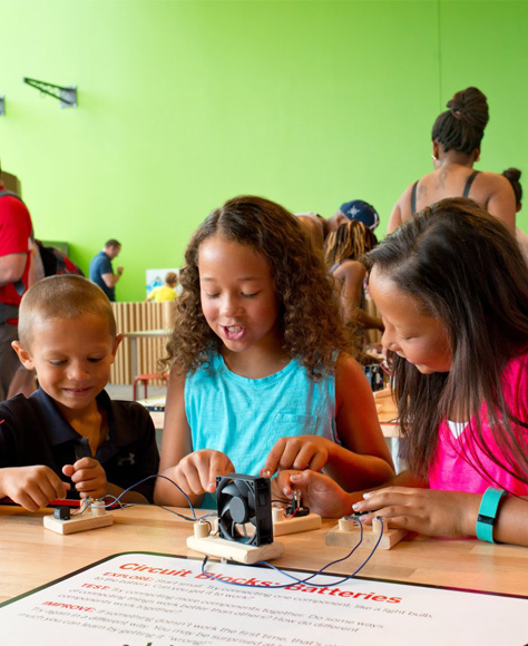 Three kids work together to solve connect and power a small fan