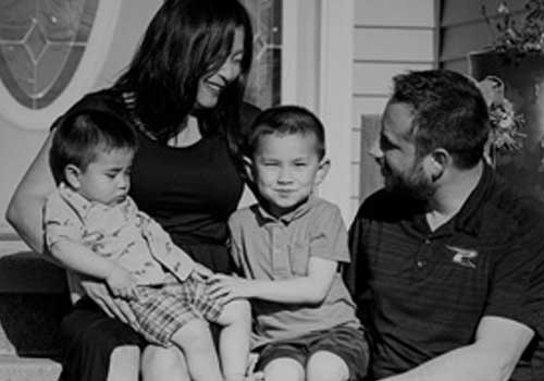 Family sitting on the front steps of their home