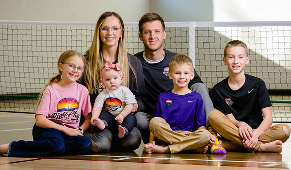 Family sitting on pickleball court